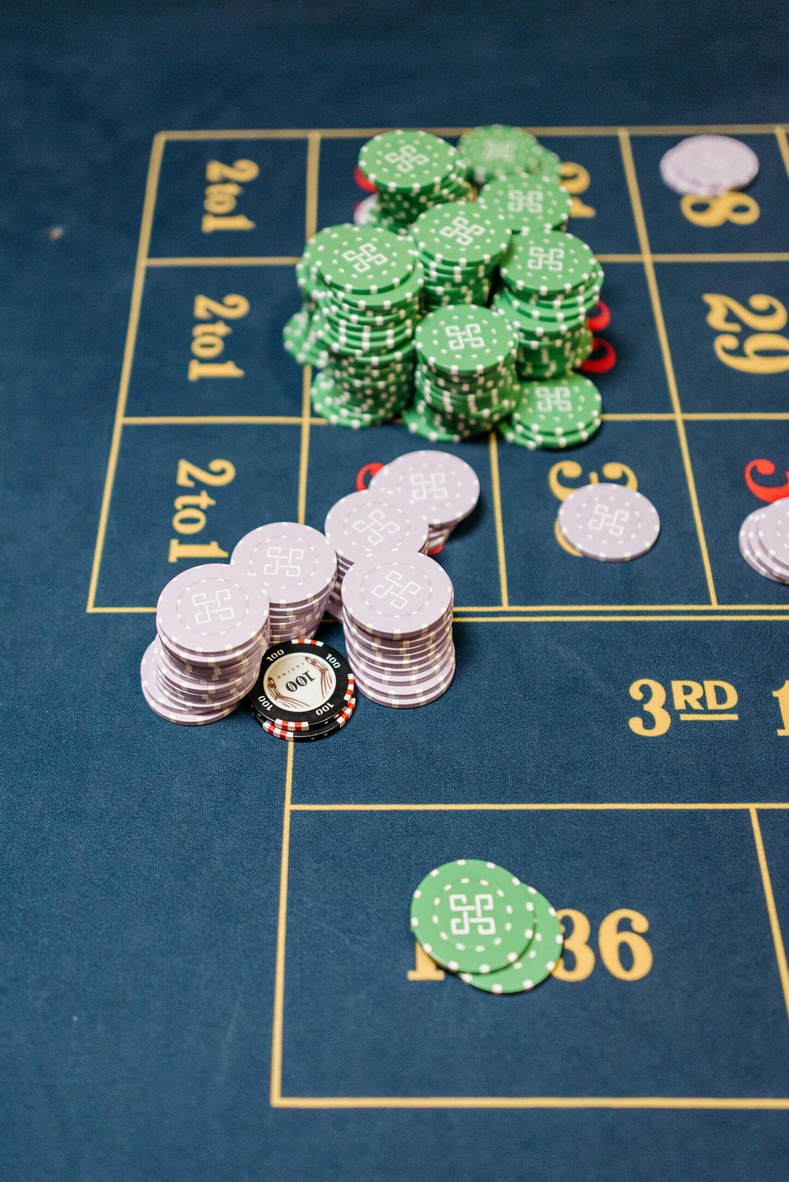 A close-up view of stacked casino chips on a roulette table during a game.